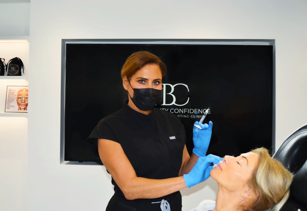 Person receiving an aesthetic injectable treatment in a clinic setting with YBC London branding.